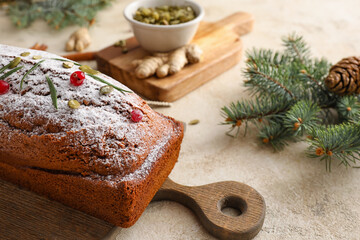 Board with tasty gingerbread cake on light background
