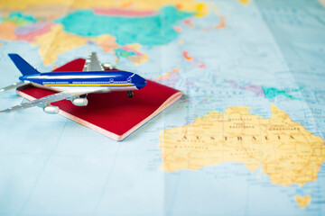 Fototapeta na wymiar toy aircraft with passport on the map, travel concept, flight to australia, trip by plane