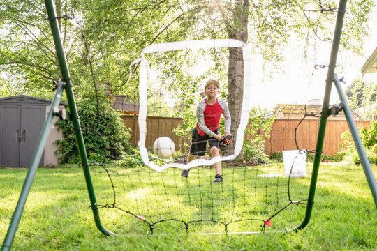 Boy throws baseball at rebounder