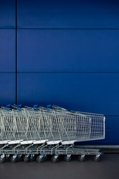 Shopping carts against a blue wall.
