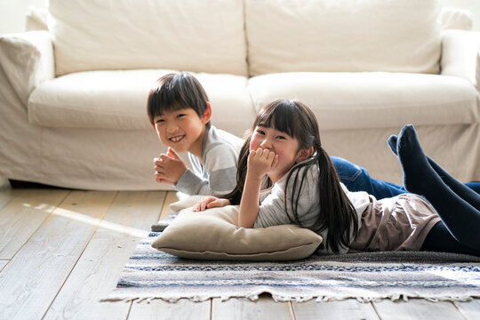 リビングの床に寝転ぶ日本人の男の子と女の子