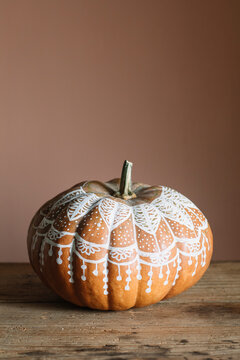 Decorated pumpkin on a wooden table