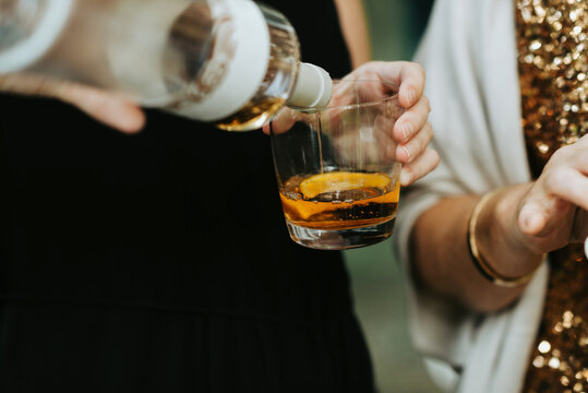 Pouring an alcoholic liquor drink with orange