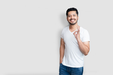 Body language concept. Creative handsome Asian guy with light beard, raising hand in ok okay gesture and smiling while liking plan isolated white background