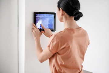 Woman using smart home security system control panel