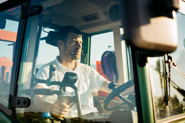 Farmer driving a tractor in vineyards during grape harvesting