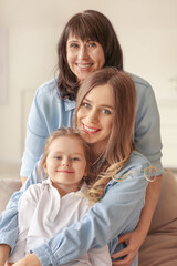 Young woman, her little daughter and mother at home