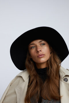 Woman in a stylish hat posing on white