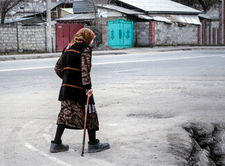 An old grandmother with a walking stick in her hands.