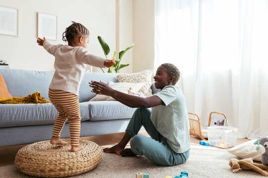 Playful Girl With Mother Having Fun At Home