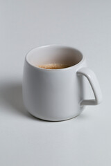 a white cup with coffee on white background