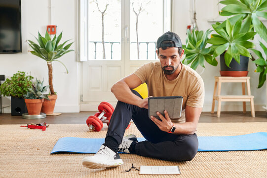 Fit young man watching exercise tutorials