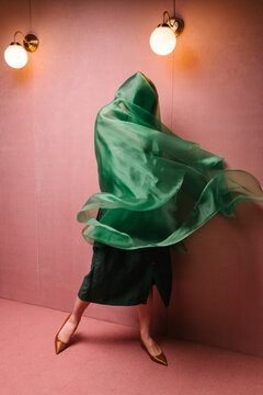 woman with green outfit in a pink room