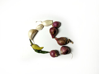 unpeeled garlic, shallots and chilies arranged in a heart shape