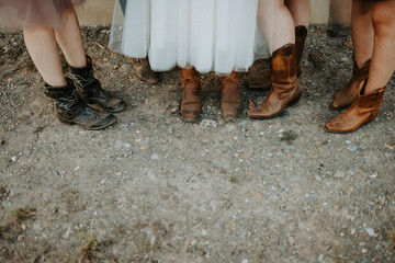 close up of bride and bridesmaids wearing cowboy boots