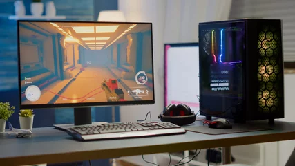 Fotobehang Gaming Professsional gaming empty room studio with neon lights and RGB powerful computer, keyboard and mouse. FPS shooter video game on pc display, stream chat on television  © DC Studio