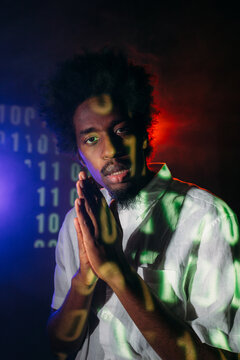 Trendy black man in studio with neon illumination