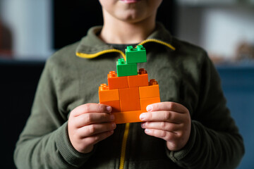 Child with pumpkin made of colored block toys