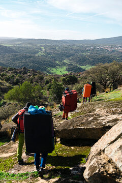 Climber friends carrying backpack and pads on forest