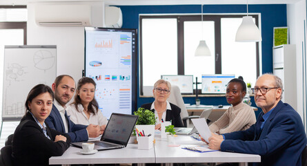 Pov of diverse team sitting in conference room during virtual meeting, discussing online with...