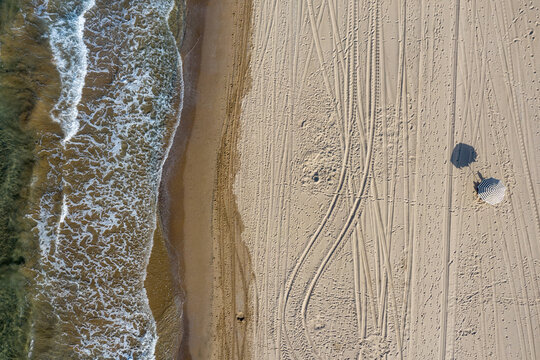 aerial shot of seashore and a beach umbrella