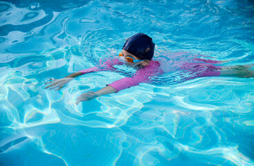 Beautiful little Asian girl playing in the swimming pool