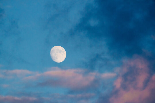 Bright moon surrounded by pink clouds
