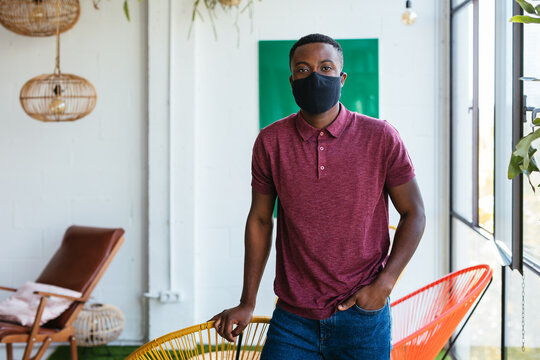 Black man in protective mask standing in creative workplace