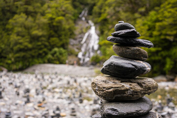 Rock stacked in front of a waterfall.