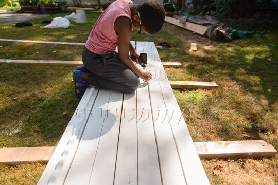 Boy drills screws into rafters
