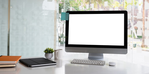 White blank screen monitor on modern working desk.