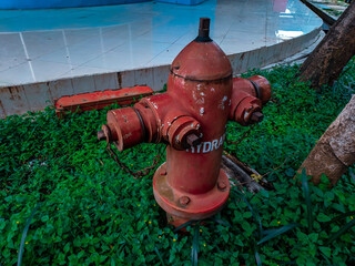 closeup photo of an old, rusty hydrant in front of the sports hall in the afternoon