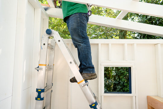Legs of a man standing on a ladder in a playhouse