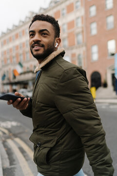 Man Crossing the Street Using a Phone