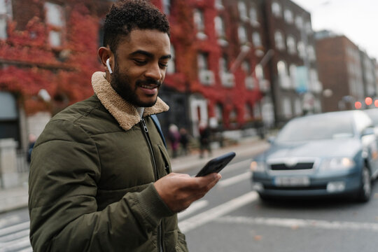 Man Crossing the Street Using a Phone