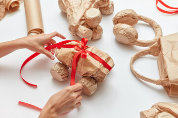 Female's hands making craft gift wrap for things.