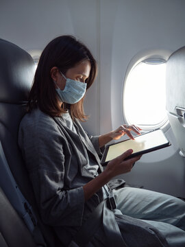 Woman wearing face mask in airplane