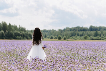 bride stand in a field of flowers on the wedding day