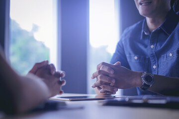 Talking about serious business. Thoughtful business peoples holding hands clasped and looking to...