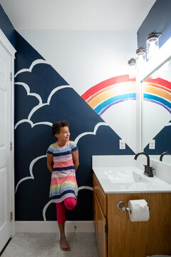 Smiling girl leans on bathroom mural wall