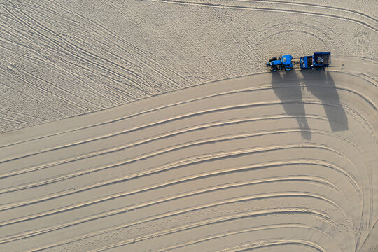 tractor cleaning a beach from above
