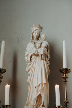 Statue Of Maria With Jesus In Between Candles