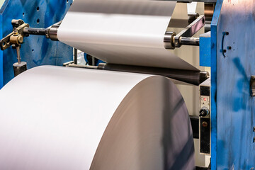 paper white roll on a machine in a printing house, blurred image