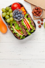 Healthy school lunch box with sandwich and fresh vegetables