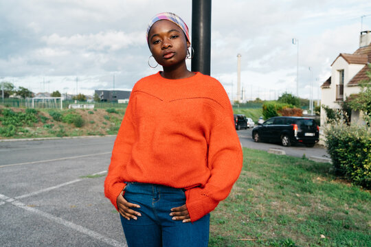 A Portrait of a teenagers wearing an orange sweater