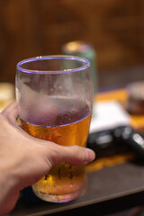 person holding a glass of cold beer