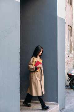 An Asian Woman Exits the Building