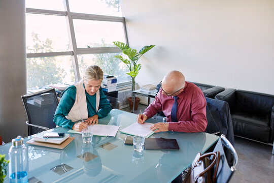 Businessman and businesswoman signing contract