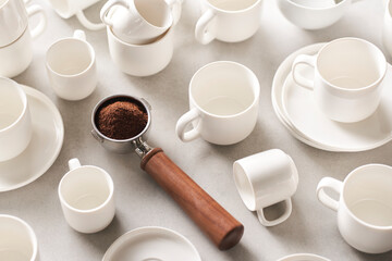 Portafilter with coffee amidst ceramic dishware