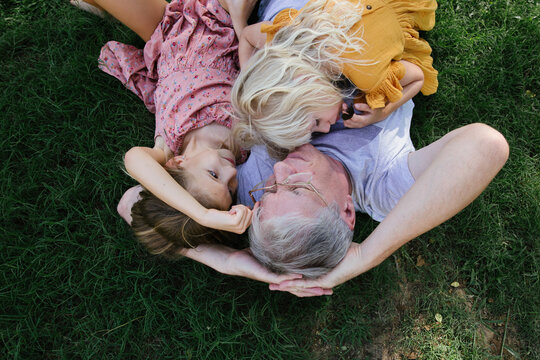 Girls with a grandfather on the grass